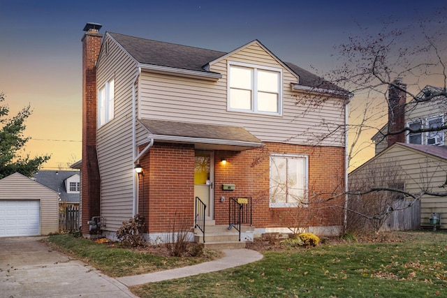 view of front of home with a yard, a garage, and an outdoor structure