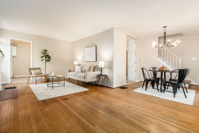 living room with light wood-type flooring and a chandelier