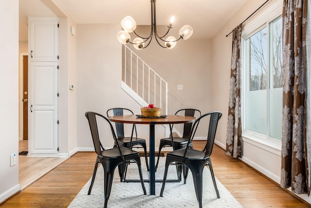 dining space featuring light hardwood / wood-style floors and an inviting chandelier