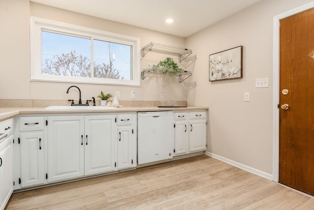 kitchen featuring dishwasher, light hardwood / wood-style floors, white cabinetry, and sink