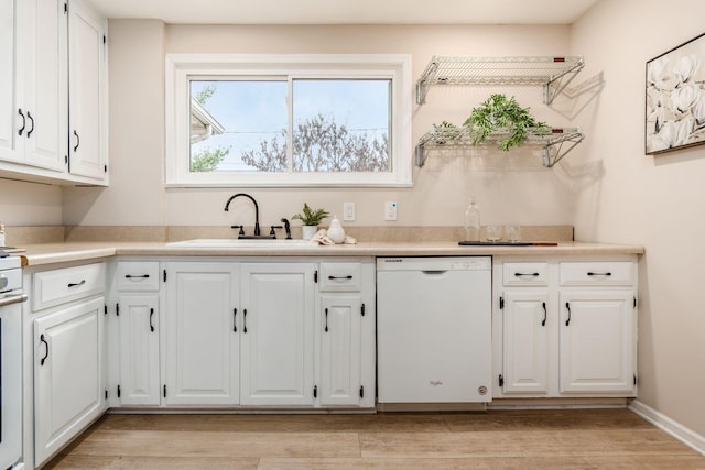 kitchen featuring white cabinetry, sink, white dishwasher, and light hardwood / wood-style floors