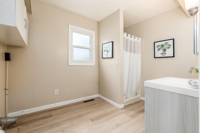 bathroom featuring hardwood / wood-style floors, curtained shower, and sink