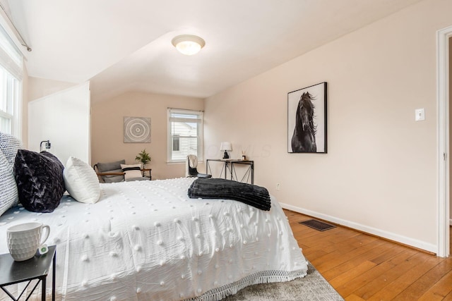 bedroom featuring hardwood / wood-style floors and vaulted ceiling