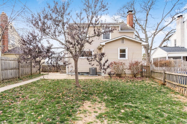 back of property featuring central AC unit and a lawn