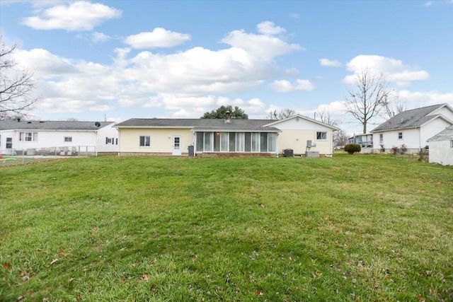 rear view of property featuring a lawn