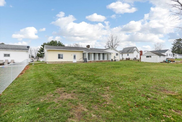 rear view of property featuring a lawn