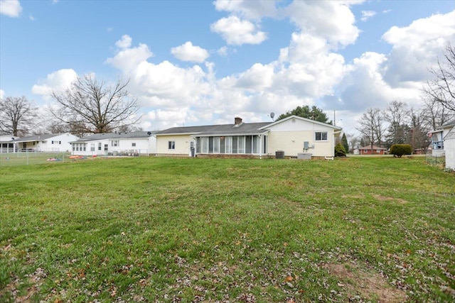 rear view of property with a yard and cooling unit