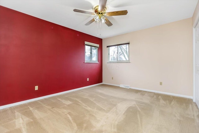 carpeted spare room with ceiling fan