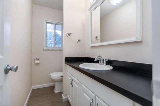 bathroom with vanity, toilet, and wood-type flooring