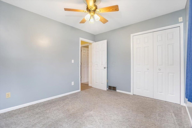 unfurnished bedroom featuring carpet, ceiling fan, and a closet