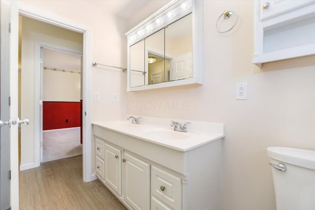 bathroom with hardwood / wood-style flooring, vanity, and toilet