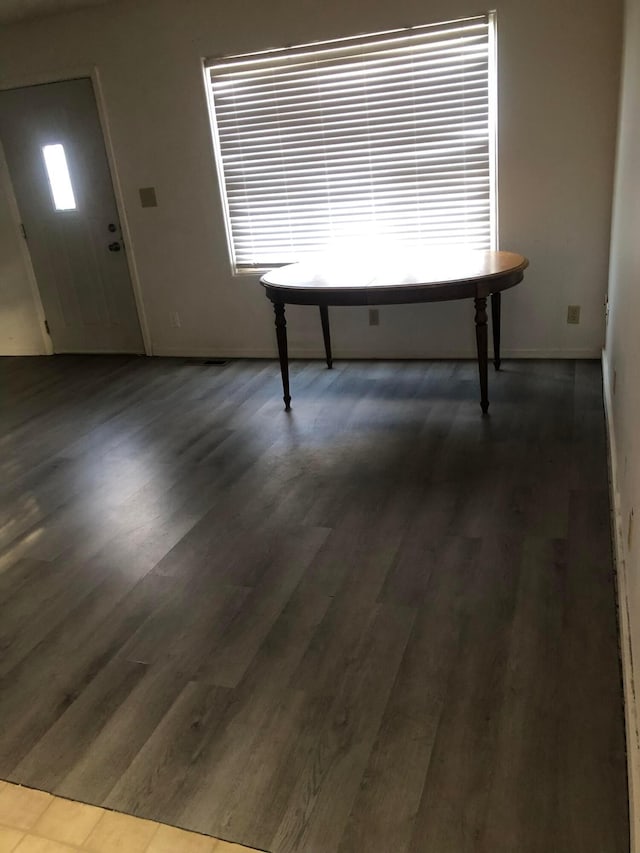 unfurnished dining area with plenty of natural light and dark hardwood / wood-style flooring