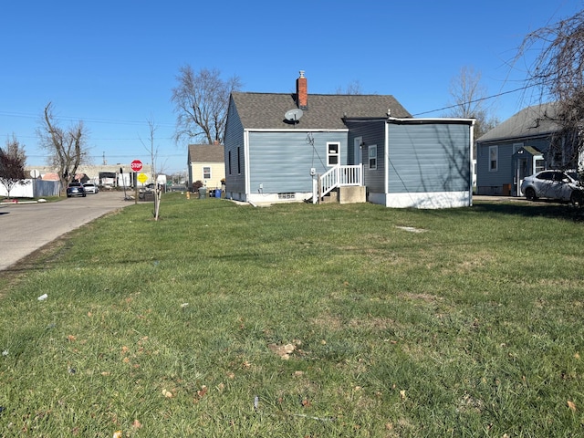 rear view of property featuring a lawn