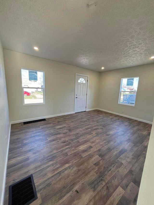 foyer entrance featuring dark wood-type flooring and a textured ceiling