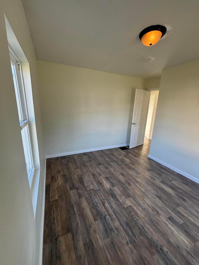 spare room featuring dark hardwood / wood-style floors and a wealth of natural light