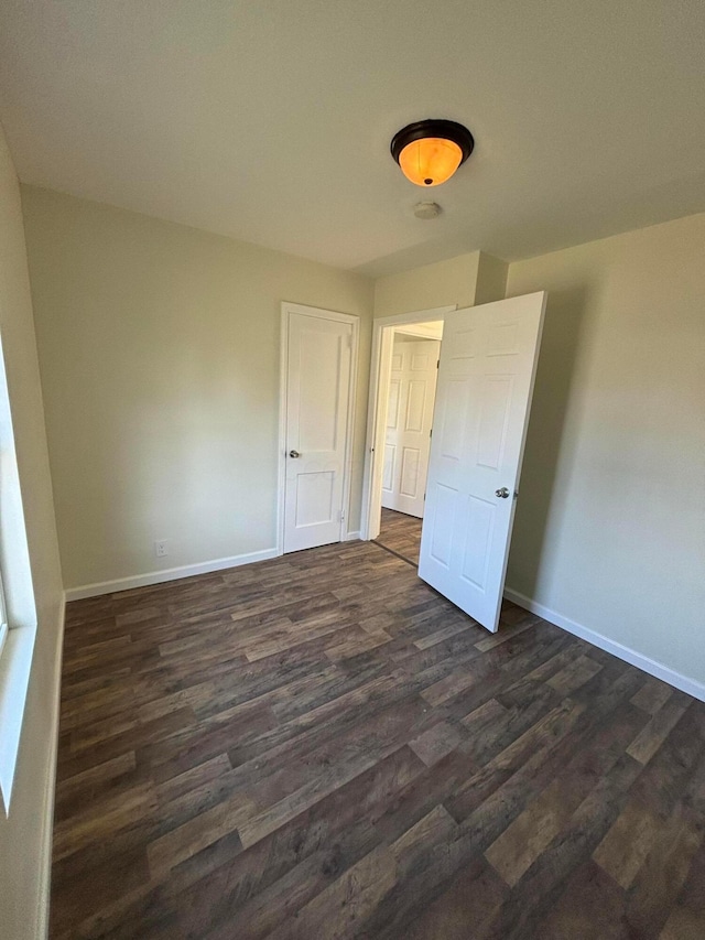 unfurnished room with dark hardwood / wood-style flooring