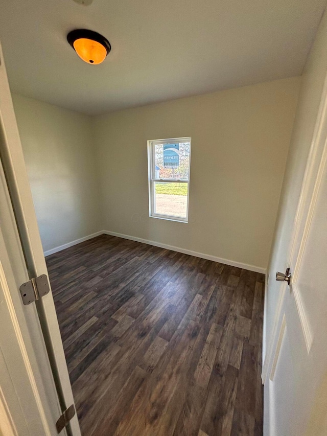 spare room with dark hardwood / wood-style flooring