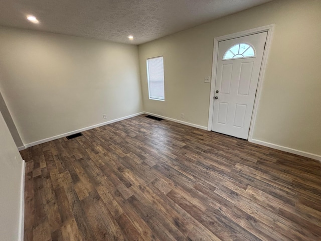 foyer entrance featuring dark wood-type flooring and a textured ceiling