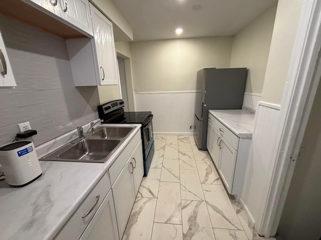 kitchen featuring appliances with stainless steel finishes, sink, and white cabinets