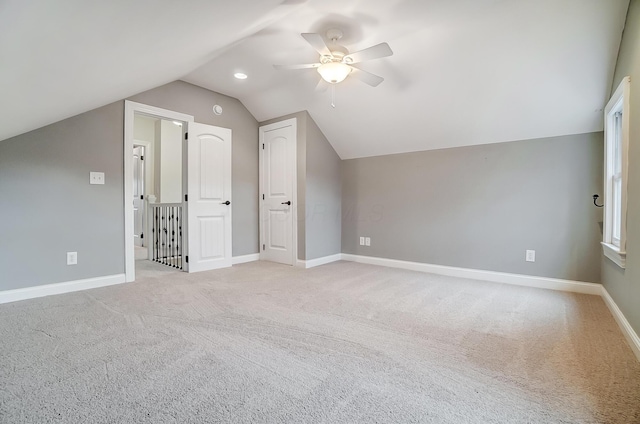 additional living space with ceiling fan, light colored carpet, and lofted ceiling