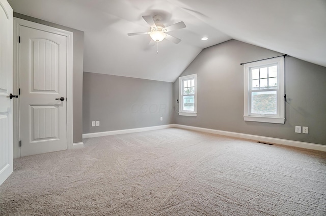 additional living space featuring ceiling fan, light colored carpet, and vaulted ceiling