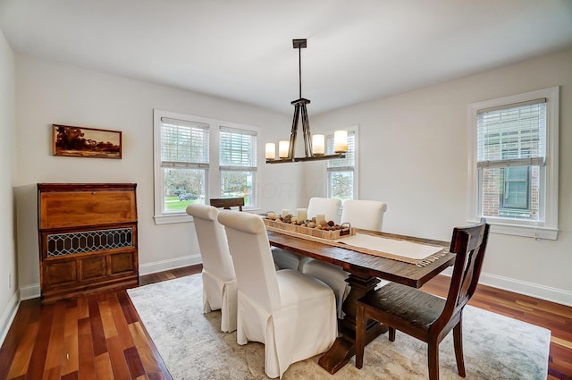 dining area featuring a wealth of natural light, dark hardwood / wood-style floors, and a notable chandelier