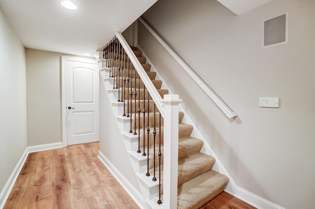 stairs featuring hardwood / wood-style floors