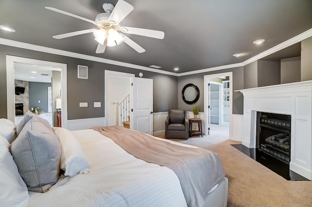 carpeted bedroom with ceiling fan, ensuite bathroom, and crown molding