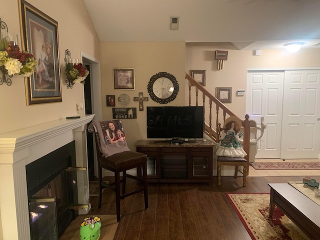 living room featuring dark hardwood / wood-style flooring and lofted ceiling