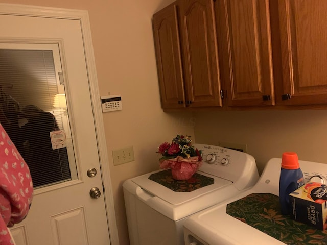 washroom featuring washer and clothes dryer and cabinets