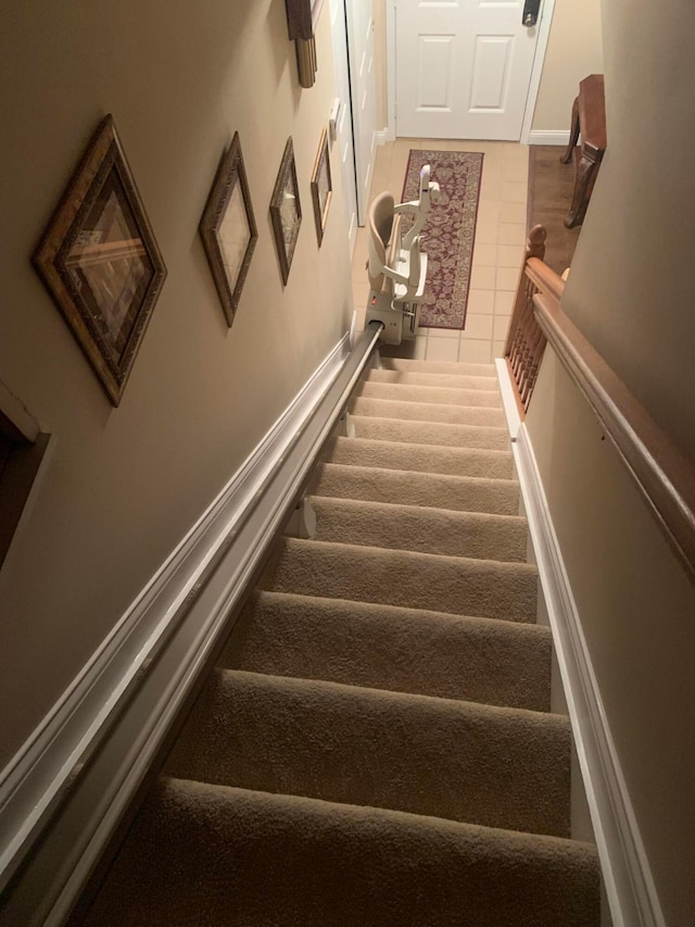 stairway featuring carpet flooring