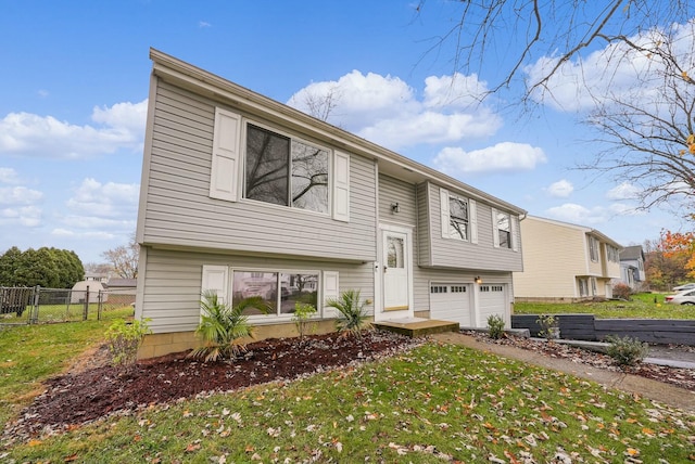 split foyer home featuring a garage and a front lawn