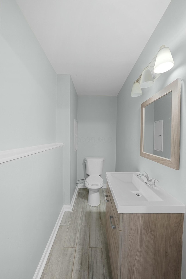 bathroom with hardwood / wood-style flooring, vanity, and toilet