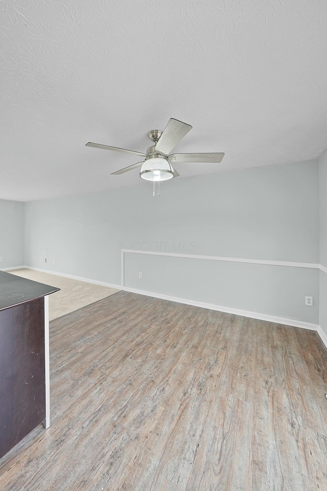 unfurnished room with ceiling fan, hardwood / wood-style floors, and a textured ceiling