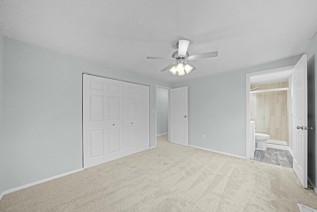 unfurnished bedroom featuring ceiling fan, a closet, light carpet, and a textured ceiling