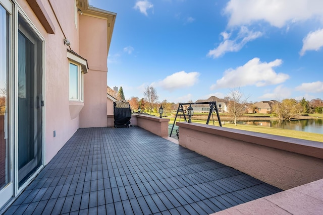 view of patio with a balcony and a water view