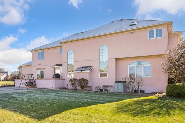 rear view of house featuring central AC, a patio area, and a lawn