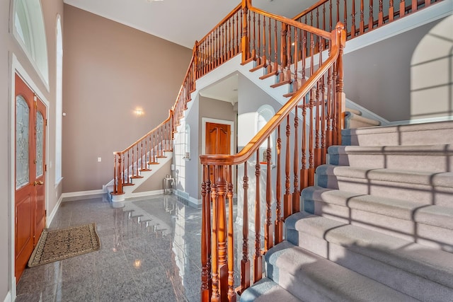 stairway featuring a towering ceiling