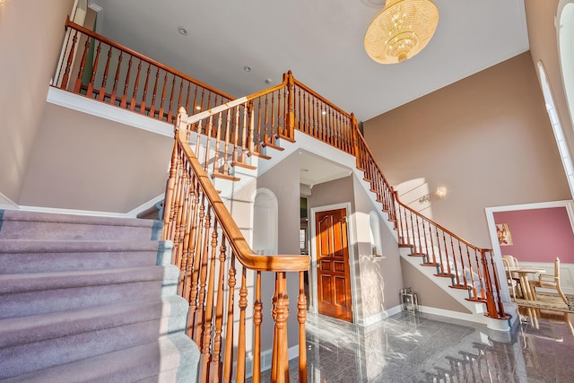 stairs with a towering ceiling and ornamental molding