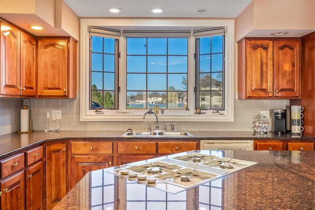 kitchen with a wealth of natural light, decorative backsplash, sink, and white appliances