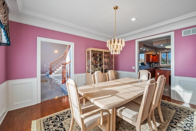 dining room with crown molding, dark wood-type flooring, and a notable chandelier