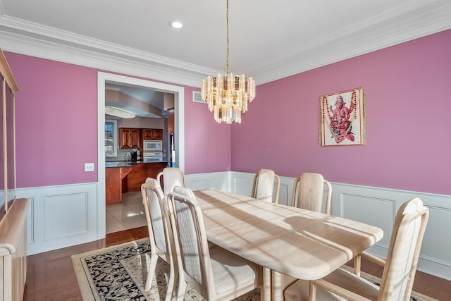 dining area with dark hardwood / wood-style flooring, crown molding, and a notable chandelier