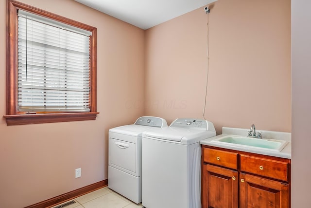 laundry room featuring washer and clothes dryer, light tile patterned flooring, cabinets, and sink