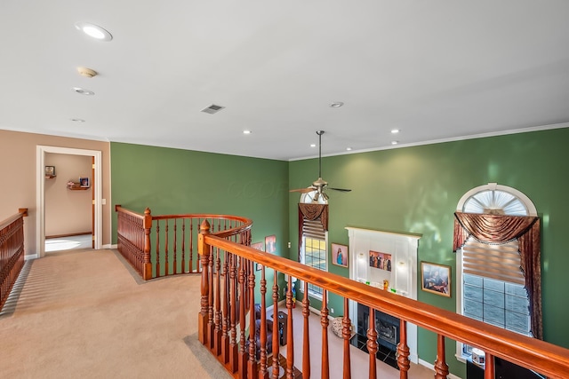 hall with crown molding and light colored carpet