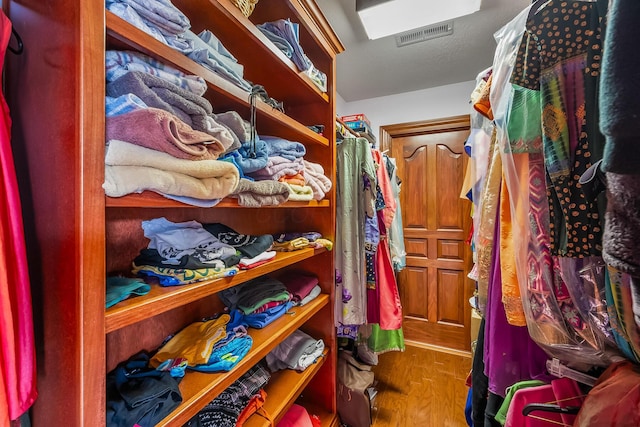 walk in closet with hardwood / wood-style floors