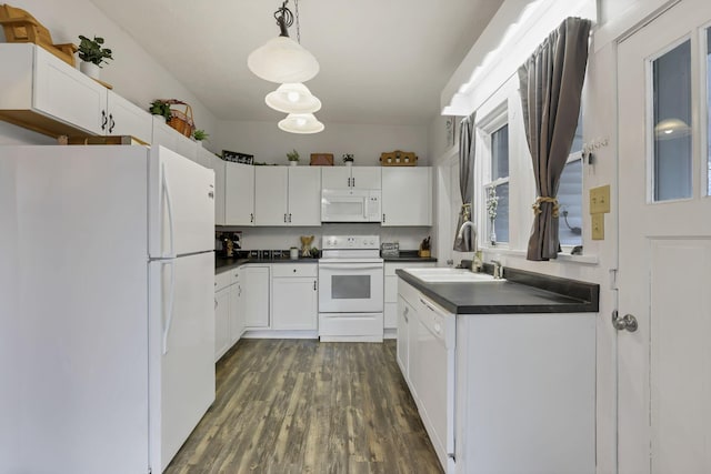 kitchen with pendant lighting, white appliances, sink, dark hardwood / wood-style floors, and white cabinetry