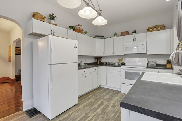 kitchen with pendant lighting, white appliances, and white cabinetry