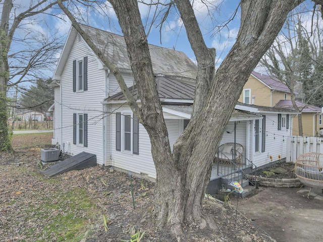 view of side of property with cooling unit and a patio area