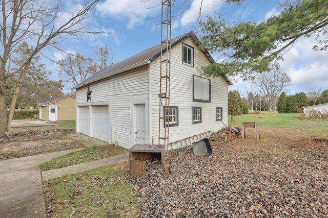 view of side of property featuring an outbuilding, a garage, and a lawn