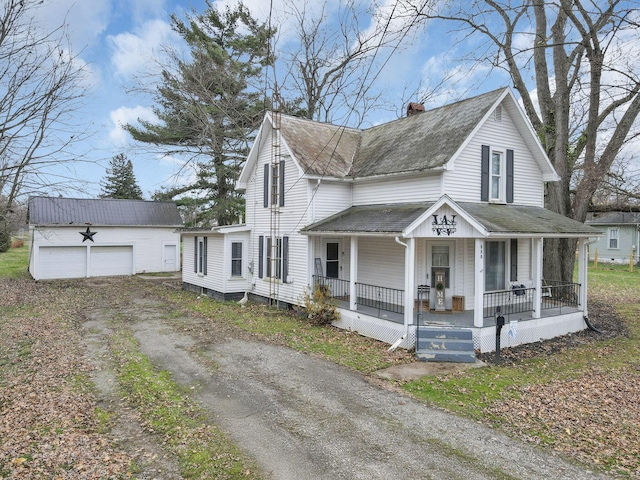 view of front of home with a porch, a garage, and an outbuilding